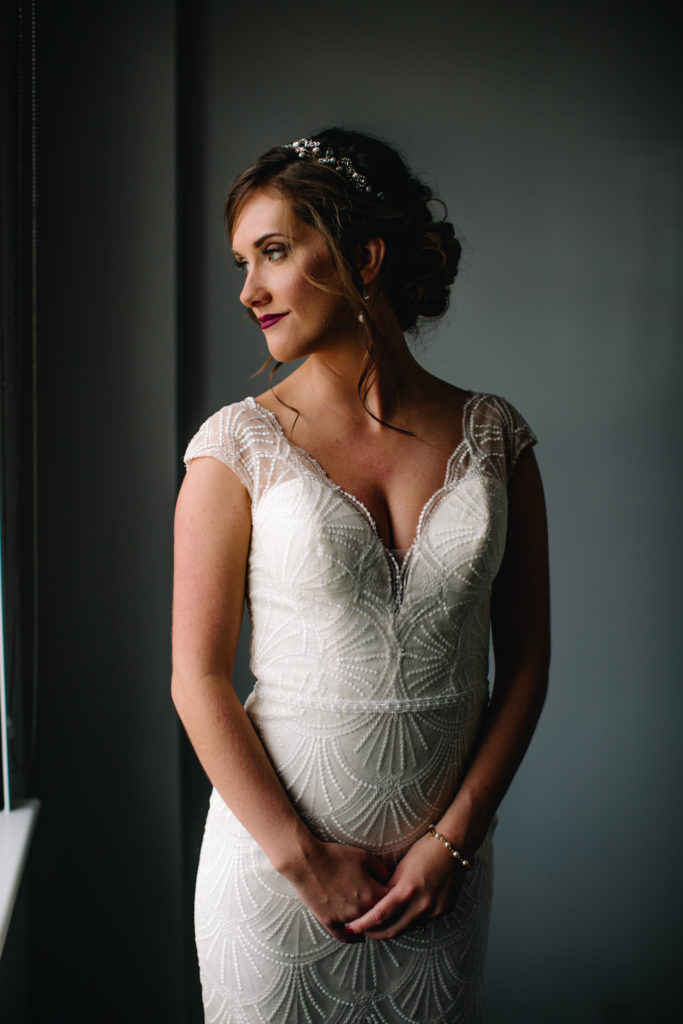 Hudson Valley bride gets ready for her wedding day in front of a window with lots of natural light